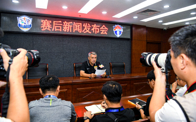 赛后新闻发布会现场，主教练接受媒体采访